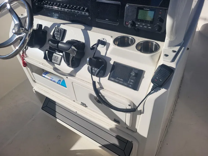 Slide: The Image of Cobia 280 Center Console 2021 dashboard with steering wheel and electronic controls. - 17