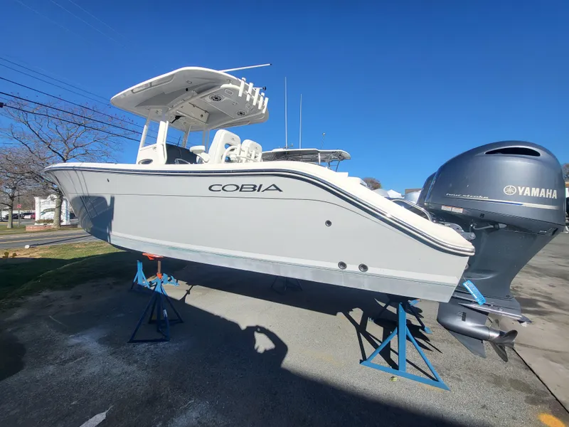Slide: The Image of 2021 Cobia 280 Center Console boat on stands, featuring Yamaha outboard motor. - 18