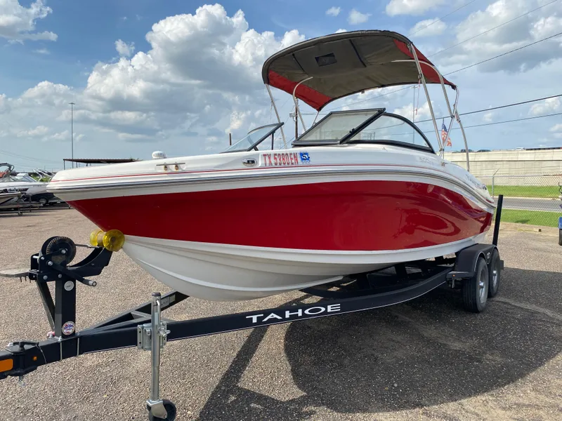 Slide: The Image of 2019 Tahoe 500 TS boat on trailer, red and white design, parked outdoors. - 2
