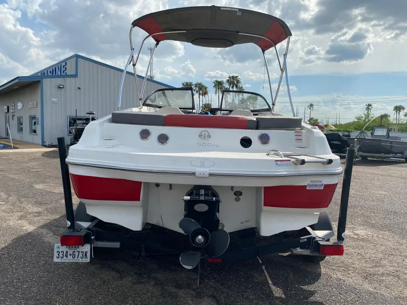 Slide: The Image of 2019 Tahoe 500 TS boat, rear view, parked outdoors under a cloudy sky. - 4
