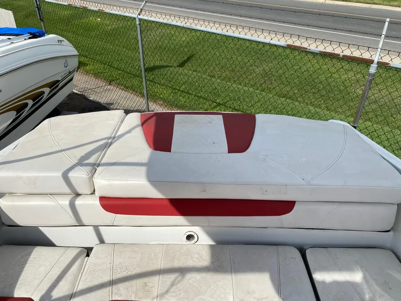 Slide: The Image of 2019 Tahoe 500 TS boat with white and red seating, parked near a chain-link fence. - 7