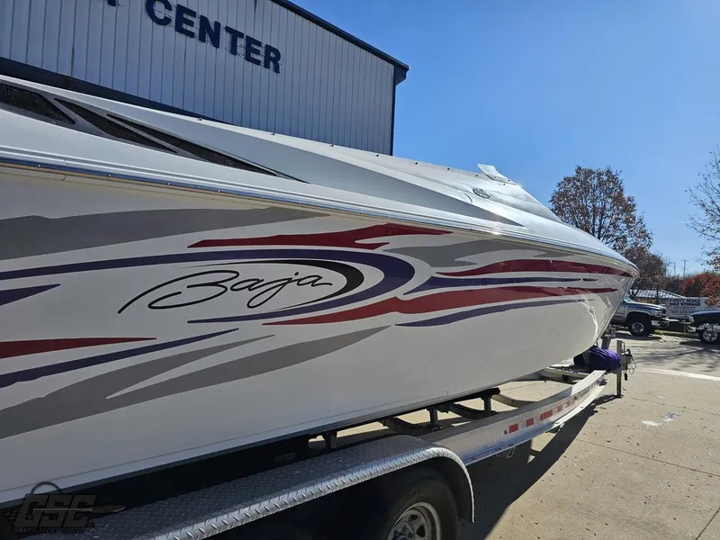Slide: The Image of 2004 Baja 33 Outlaw boat on trailer, vibrant graphics, sunny day. - 10