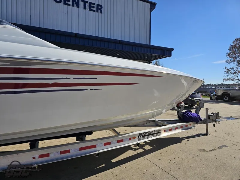Slide: The Image of 2004 Baja 33 Outlaw boat on trailer, parked outside a building. - 11