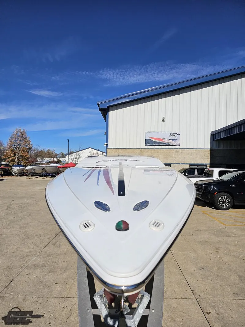 Slide: The Image of 2004 Baja 33 Outlaw boat on trailer, parked outside a warehouse under clear blue sky. - 14