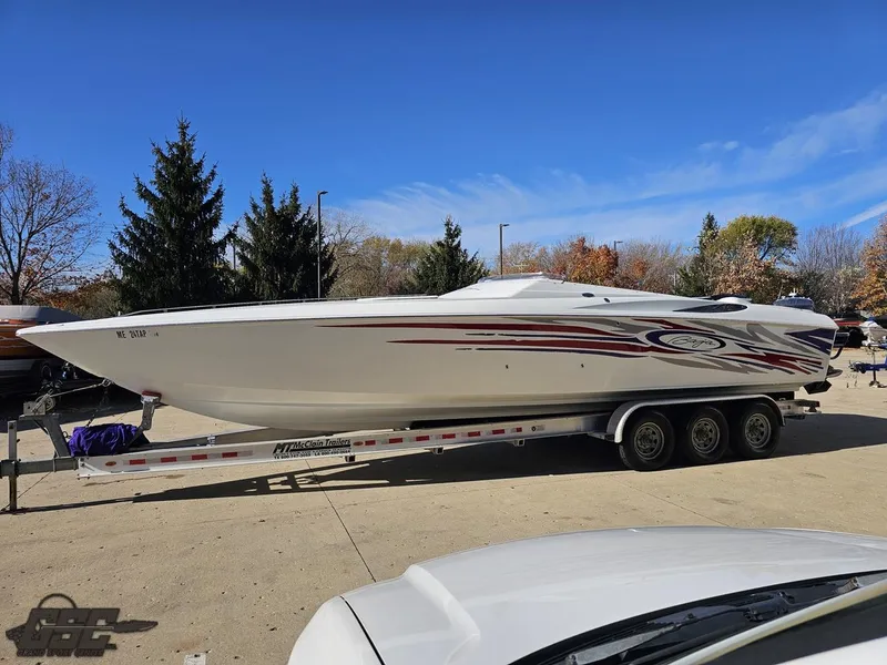 Slide: The Image of 2004 Baja 33 Outlaw speedboat on trailer, parked outdoors under clear blue sky. - 16