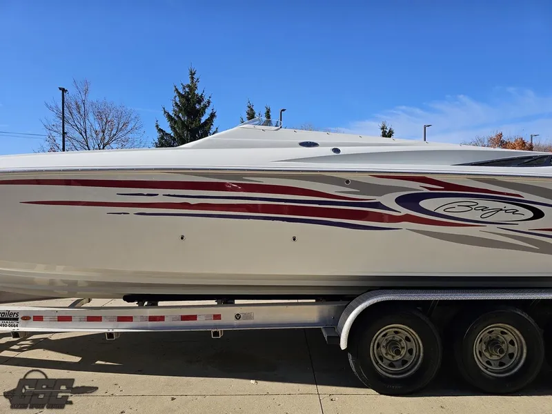 Slide: The Image of 2004 Baja 33 Outlaw boat on trailer, side view with vibrant graphics. - 19