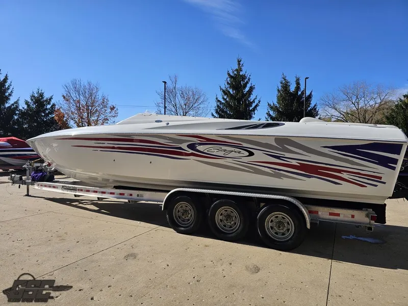 Slide: The Image of 2004 Baja 33 Outlaw speedboat on trailer, vibrant graphics, parked outdoors. - 22