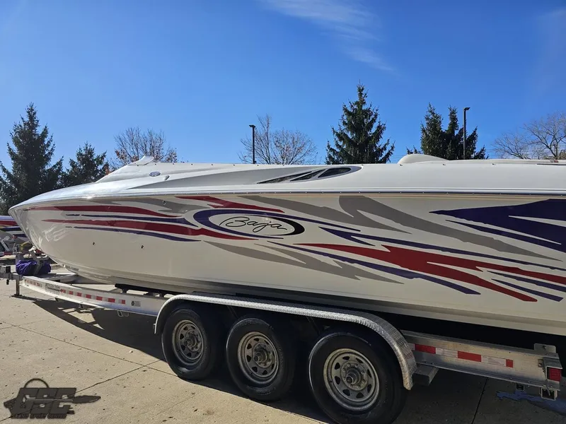 Slide: The Image of 2004 Baja 33 Outlaw speedboat on trailer, featuring vibrant red and blue graphics. - 24