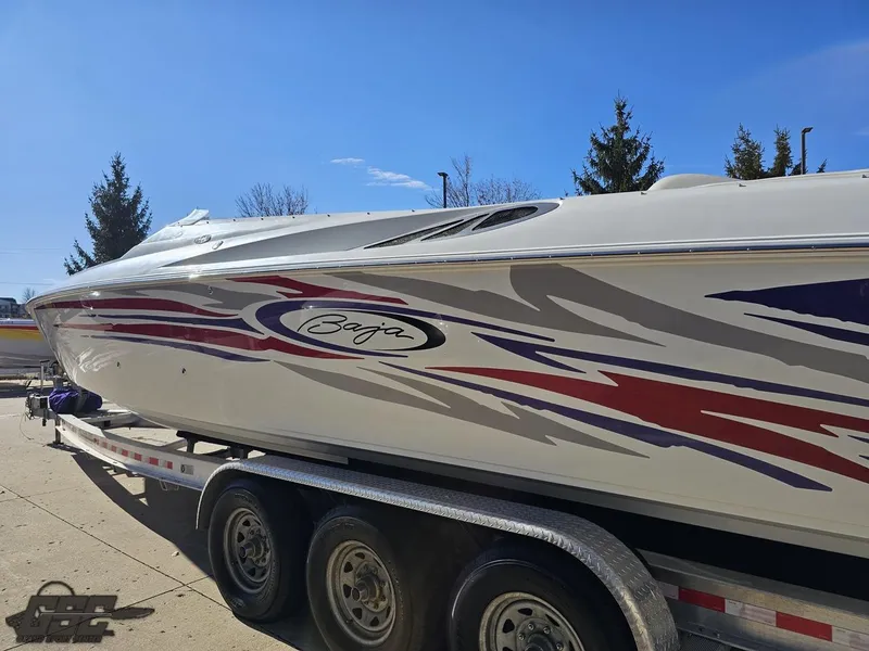 Slide: The Image of 2004 Baja 33 Outlaw speedboat on trailer with vibrant graphics. - 25