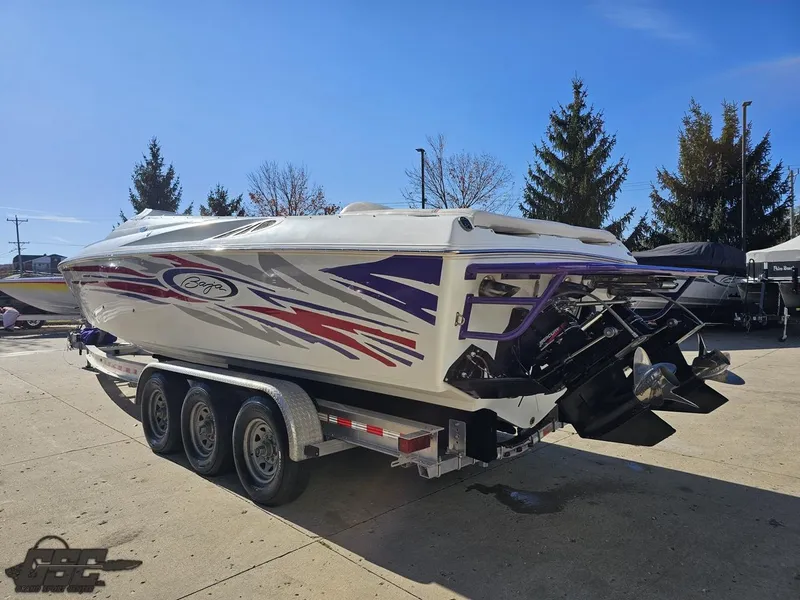 Slide: The Image of 2004 Baja 33 Outlaw speedboat on trailer, vibrant graphics, parked outdoors. - 26