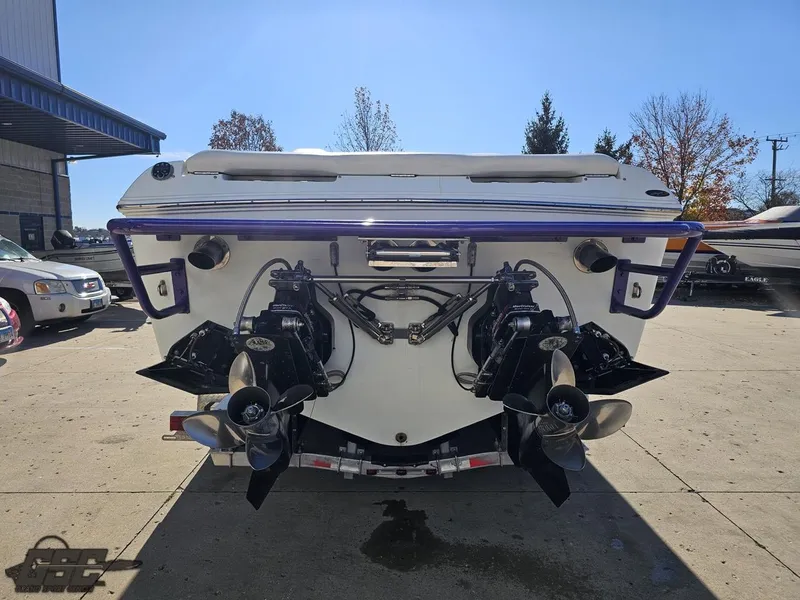 Slide: The Image of 2004 Baja 33 Outlaw boat rear view with dual propellers in a sunny outdoor setting. - 28
