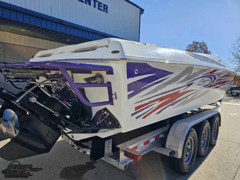 Slide: The Image of 2004 Baja 33 Outlaw speedboat on trailer, featuring vibrant graphics and triple-axle support. - 31