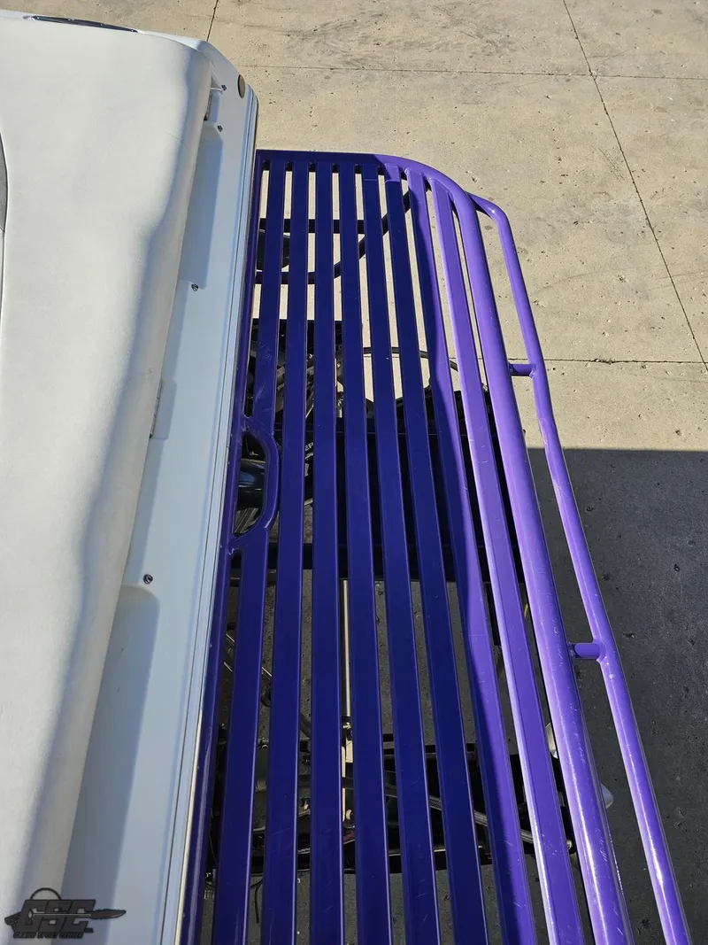 Slide: The Image of 2004 Baja 33 Outlaw boat with purple railing on concrete surface. - 32