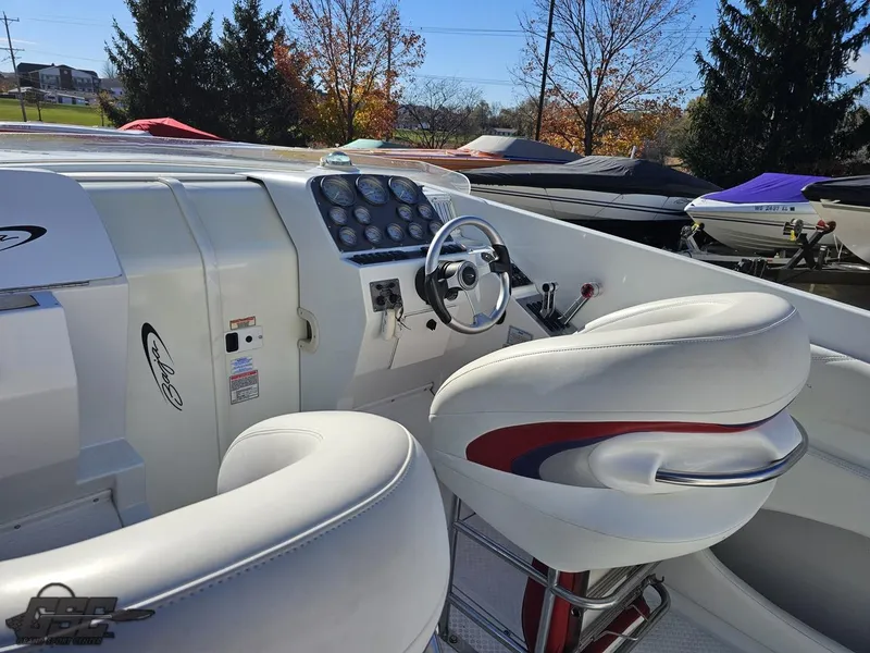 Slide: The Image of 2004 Baja 33 Outlaw boat cockpit with white seating and control panel. - 42