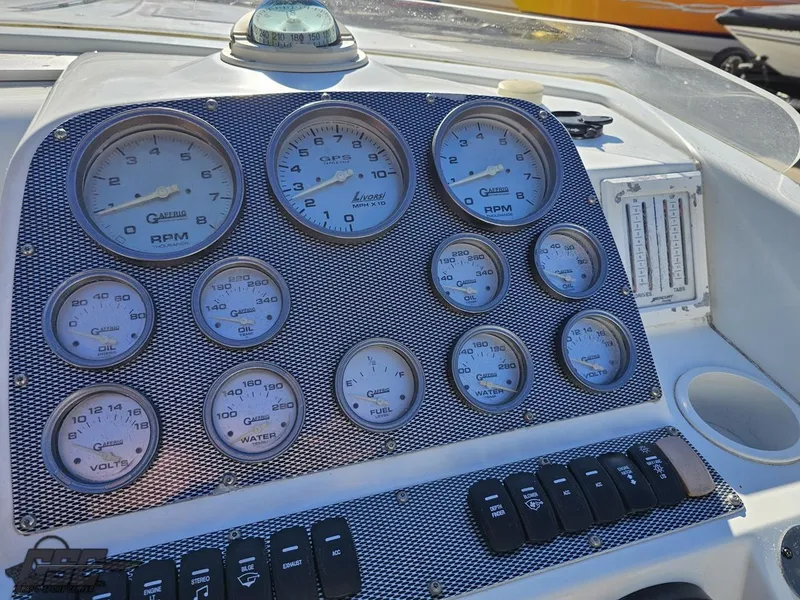 Slide: The Image of Dashboard of a 2004 Baja 33 Outlaw boat with multiple gauges and controls. - 47