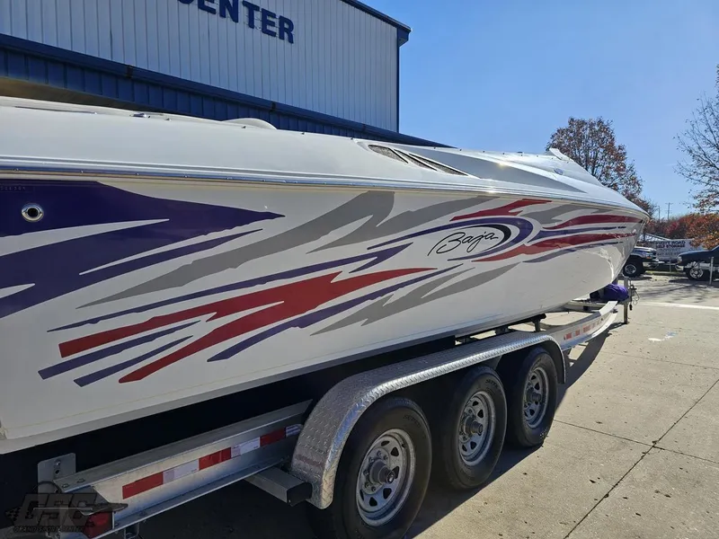 Slide: The Image of 2004 Baja 33 Outlaw boat with vibrant graphics on a trailer. - 9