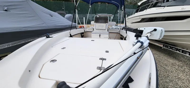 Slide: The Image of 2005 Young Boats Young 20, white deck, parked with other boats, featuring a trolling motor. - 11