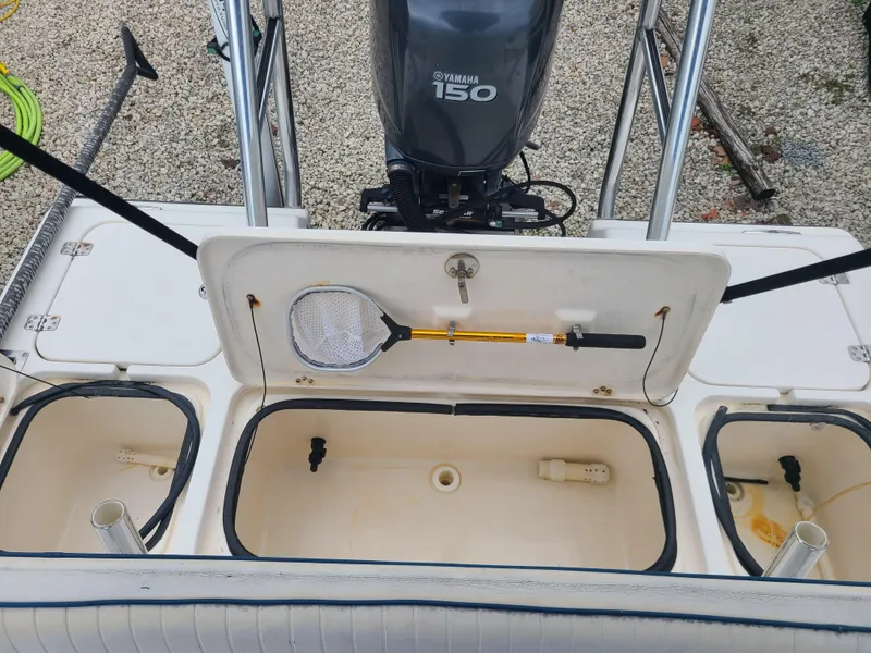 Slide: The Image of 2005 Young Boats Young 20 with Yamaha 150 engine, open storage compartments, and fishing net. - 12