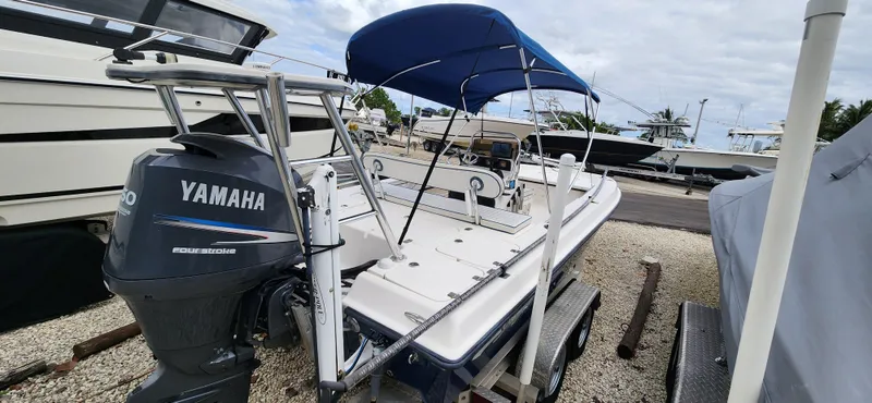 Slide: The Image of 2005 Young Boats Young 20 with Yamaha engine, parked on a trailer under a blue canopy. - 16