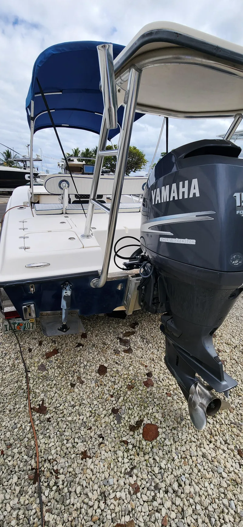 Slide: The Image of 2005 Young Boats Young 20 with Yamaha outboard motor, parked on gravel. - 17