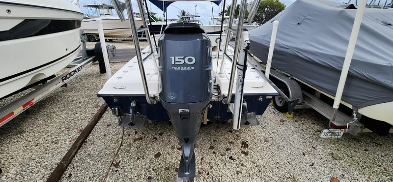 Slide: The Image of 2005 Young Boats Young 20 with 150 HP engine, parked on gravel lot. - 18