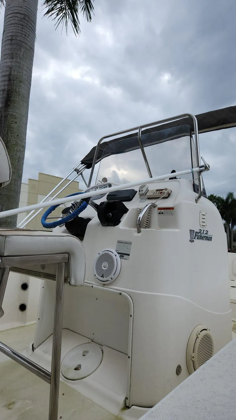 Slide: The Image of 2005 Young Boats Young 20 console with steering wheel, under cloudy sky. - 23