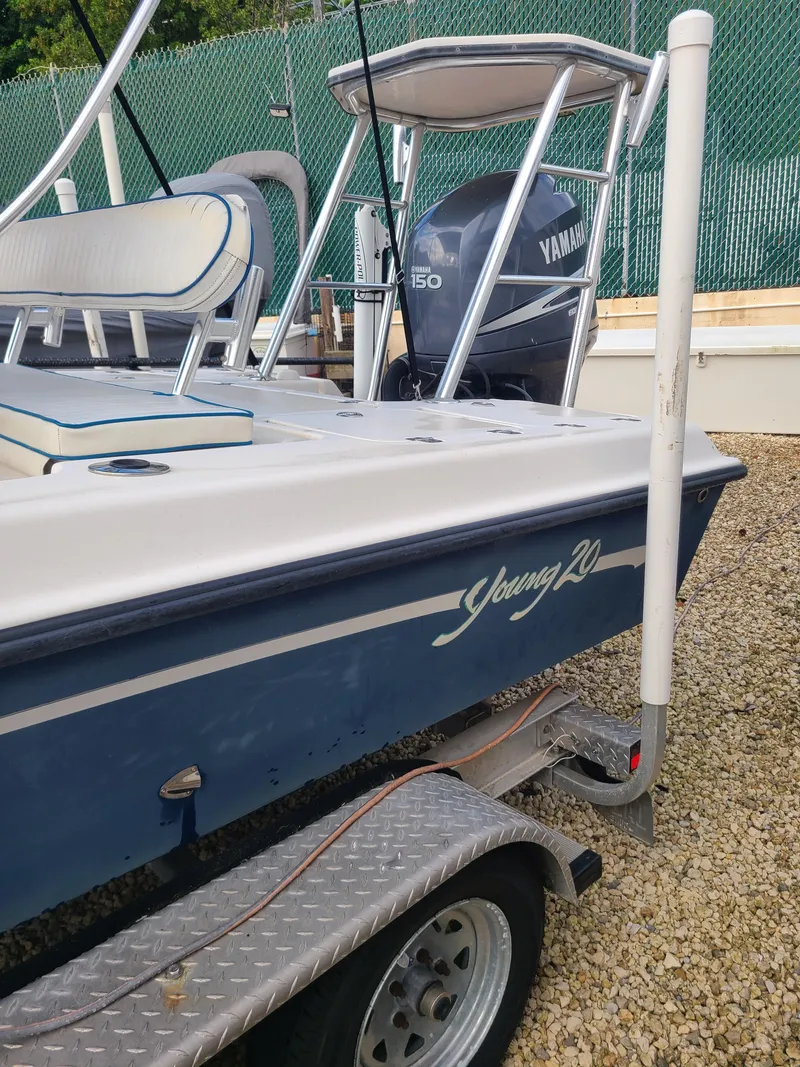 Slide: The Image of 2005 Young Boats Young 20 on trailer with Yamaha 150 engine, parked on gravel. - 24