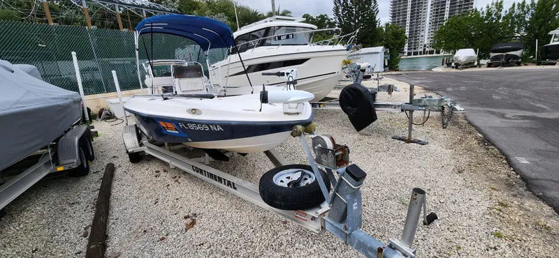 Slide: The Image of 2005 Young Boats Young 20 on trailer, parked in marina with other boats. - 4