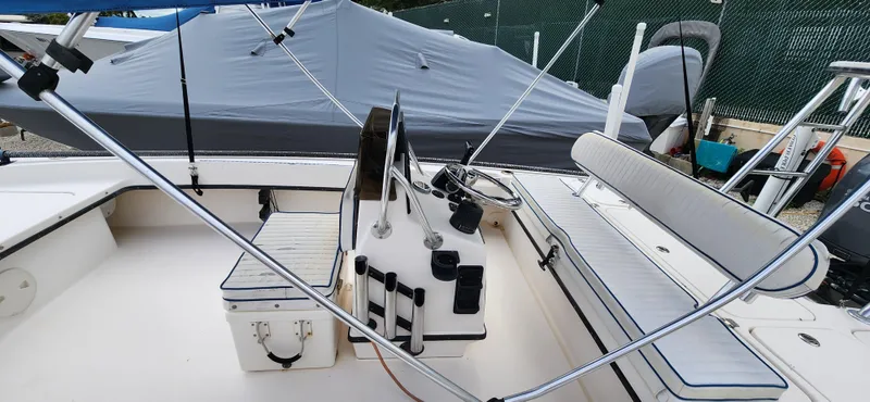 Slide: The Image of 2005 Young Boats Young 20 interior with seating and steering console, docked under cover. - 6