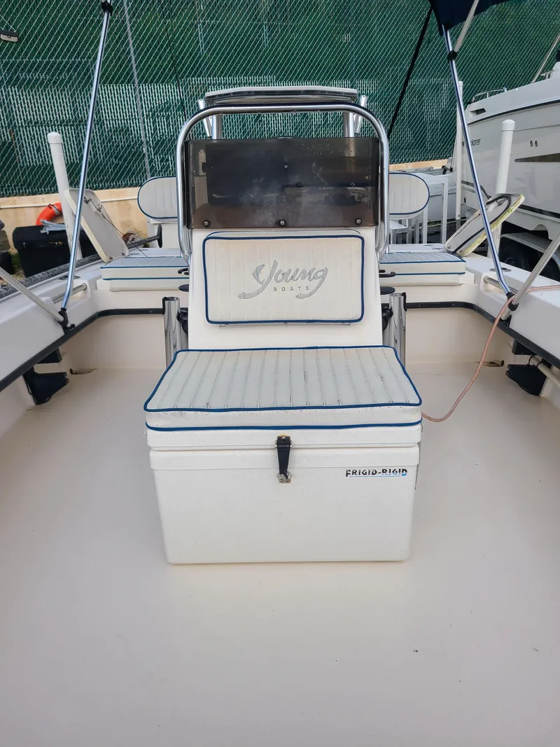 Slide: The Image of 2005 Young Boats Young 20 interior with seating and console, featuring Frigid-Rigid cooler. - 7