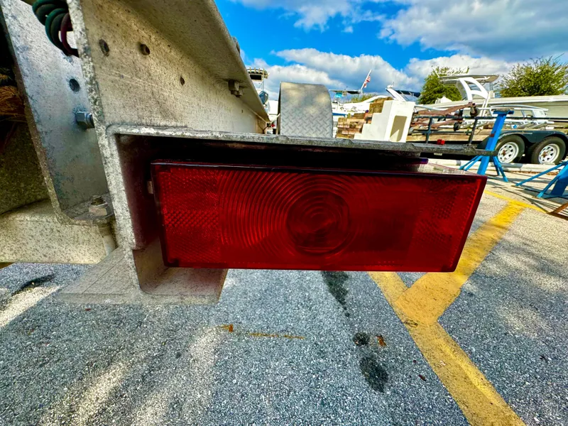 Slide: The Image of Close-up of a 2016 REAL X Model R32X trailer's red taillight in a parking lot. - 12
