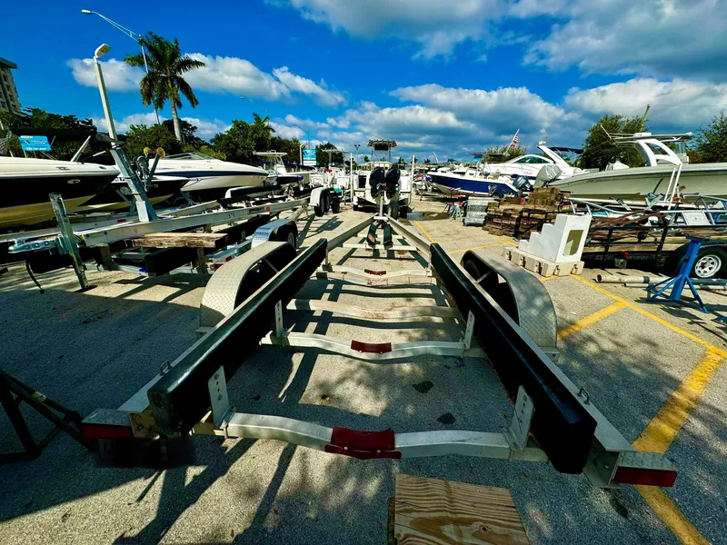 Slide: The Image of Boat trailer REAL X Model R32X 2016 in a marina with boats and palm trees. - 14