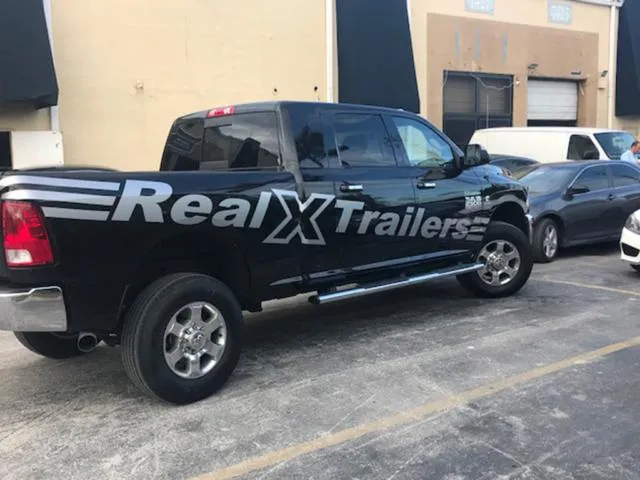 Slide: The Image of Black truck with "Real X Trailers" branding, parked in a lot, 2016 REAL X Model R32X. - 25