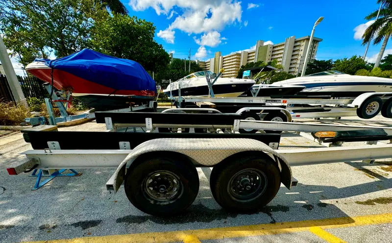Slide: The Image of 2016 REAL X Model R32X trailer with boats in a sunny parking lot. - 4