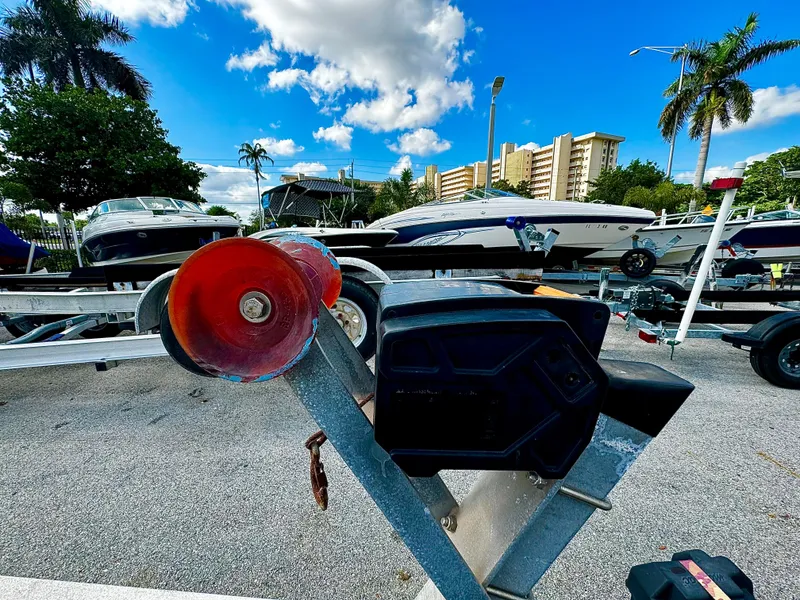 Slide: The Image of Boat trailer REAL X Model R32X (2016) in a marina, surrounded by boats and palm trees. - 7