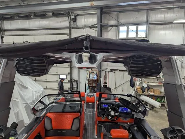 Slide: The Image of 2020 Nautique G23 Paragon boat interior with advanced dashboard and seating in a garage. - 12