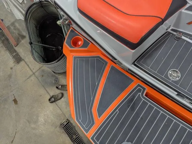 Slide: The Image of 2020 Nautique G23 Paragon boat with orange and gray deck details in a garage setting. - 18