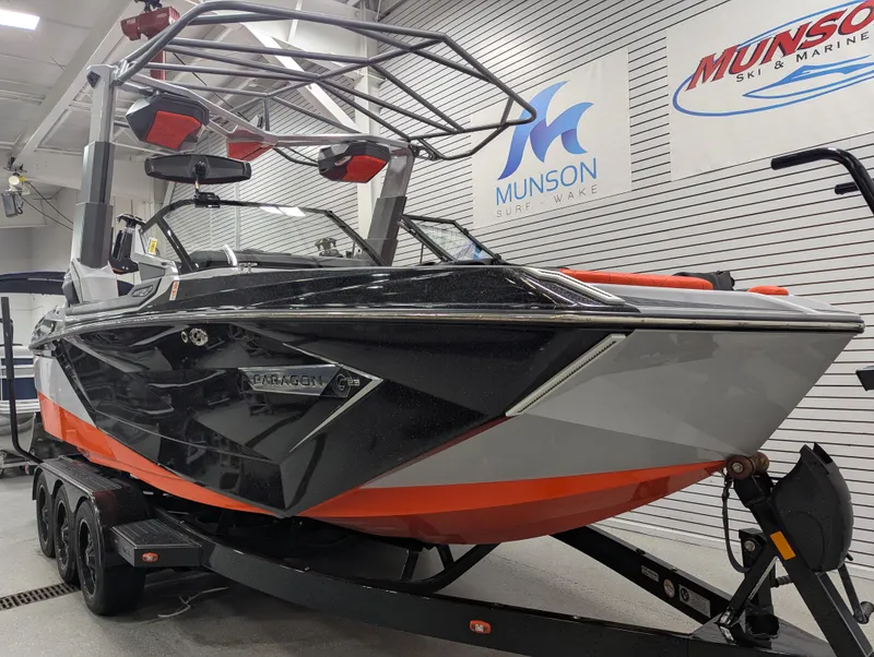 Slide: The Image of 2020 Nautique G23 Paragon boat in showroom, black and orange design, on trailer. - 27