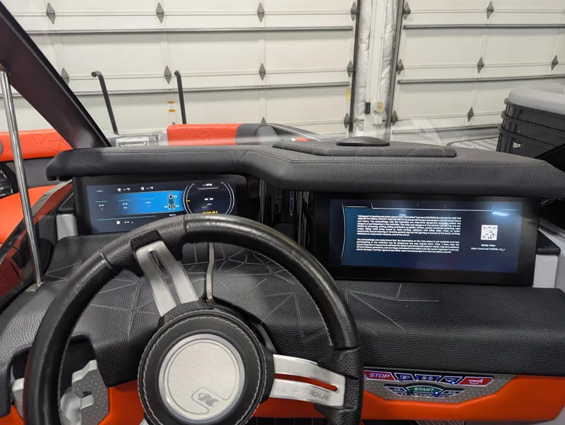 Slide: The Image of 2020 Nautique G23 Paragon dashboard with digital displays and steering wheel in a garage setting. - 28