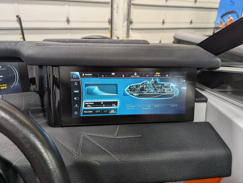 Slide: The Image of 2020 Nautique G23 Paragon dashboard display with advanced control interface in a garage setting. - 29