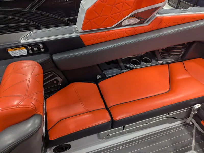 Slide: The Image of 2020 Nautique G23 Paragon interior with orange and black seating, cup holders, and modern design. - 34