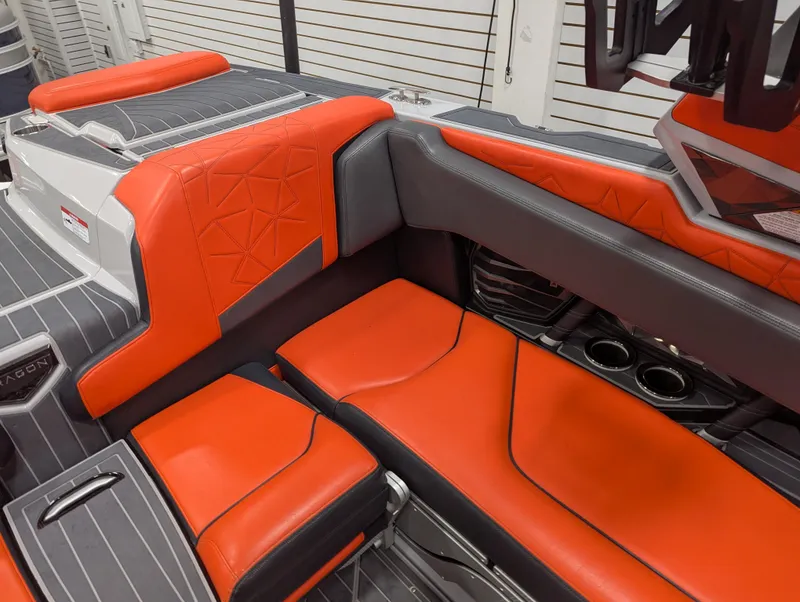 Slide: The Image of 2020 Nautique G23 Paragon interior with orange and gray seating, featuring cup holders and sleek design. - 36