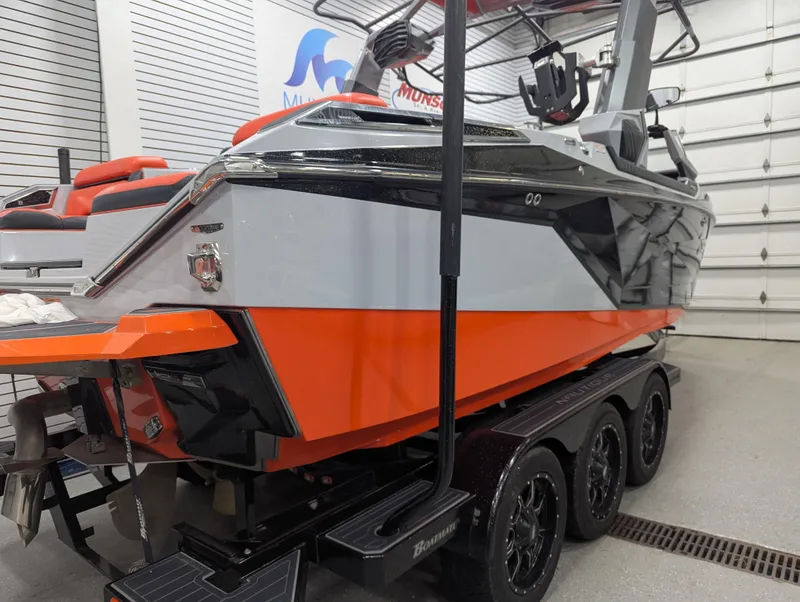 Slide: The Image of 2020 Nautique G23 Paragon boat in showroom, featuring orange and gray design on a triple-axle trailer. - 4