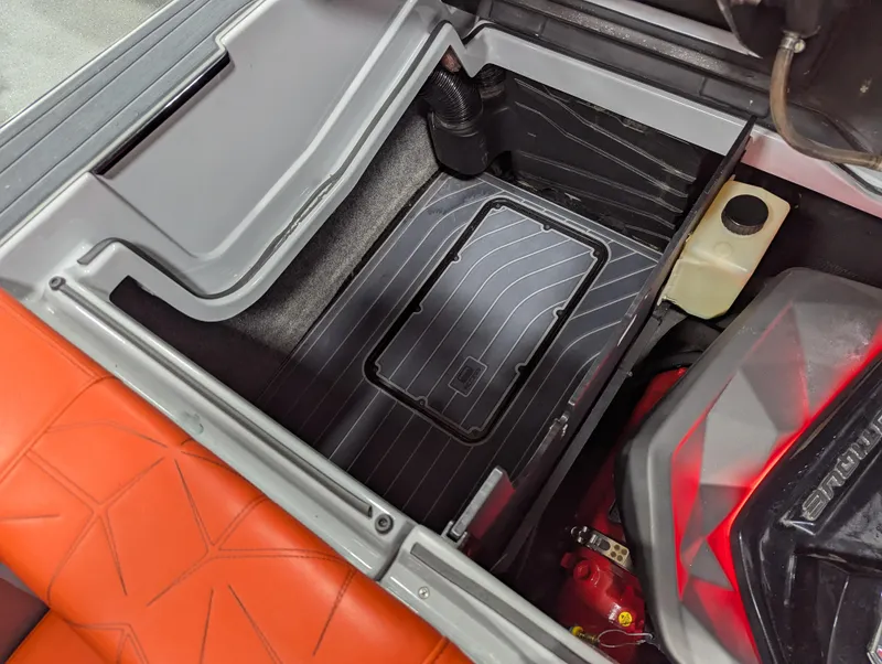 Slide: The Image of 2020 Nautique G23 Paragon engine compartment with orange seating and storage area. - 44