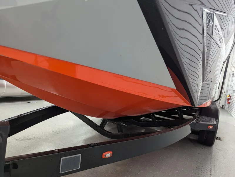 Slide: The Image of 2020 Nautique G23 Paragon boat on trailer, featuring sleek orange and gray hull design. - 47
