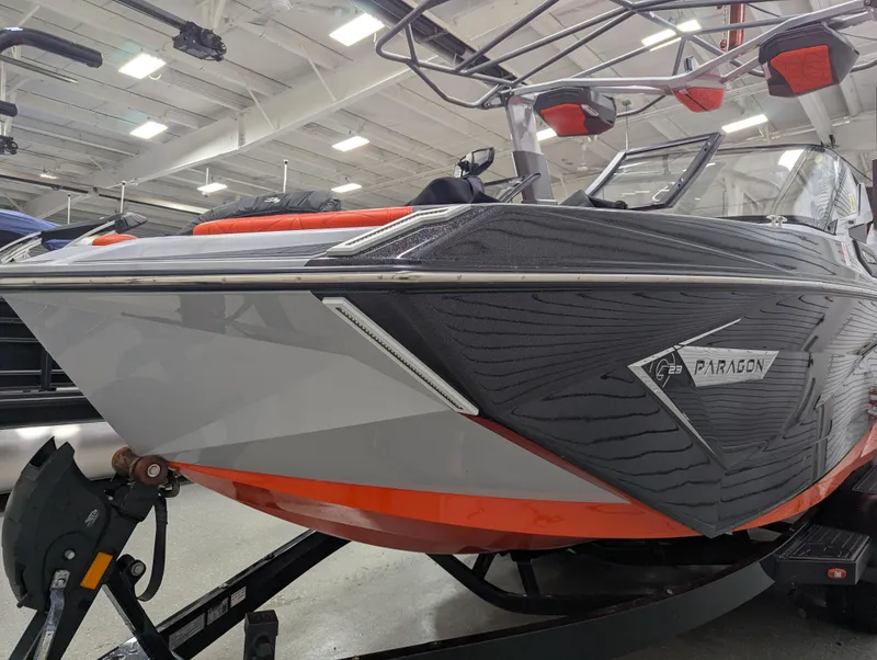 Slide: The Image of 2020 Nautique G23 Paragon boat in showroom, featuring sleek design and vibrant orange accents. - 6