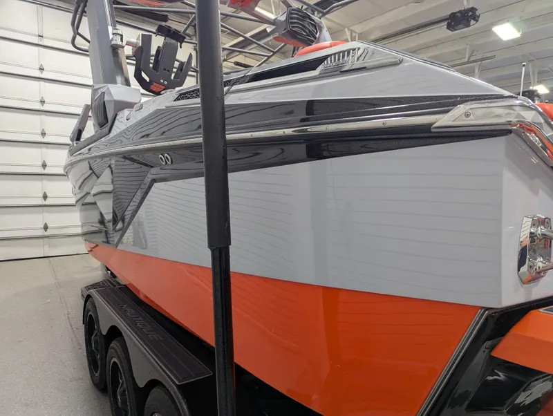 Slide: The Image of 2020 Nautique G23 Paragon boat in a showroom, featuring sleek design and vibrant orange accents. - 8