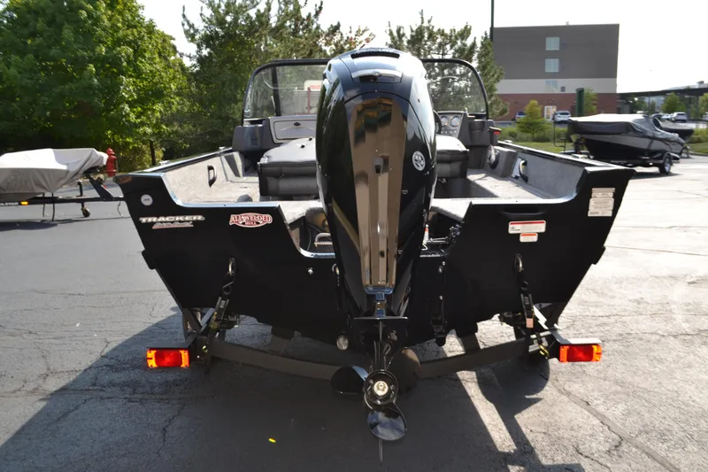 Slide: The Image of 2025 Tracker Pro Guide V-16 WT boat with outboard motor, parked outdoors. - 2