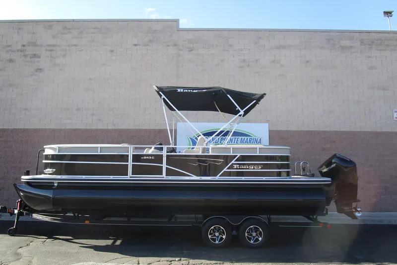 The Image of 2024 Ranger Reata 243C pontoon boat with canopy, displayed on a trailer. - 0
