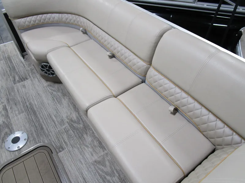 Slide: The Image of 2024 Ranger Reata 243C boat interior with beige cushioned seating and wood-style flooring. - 10